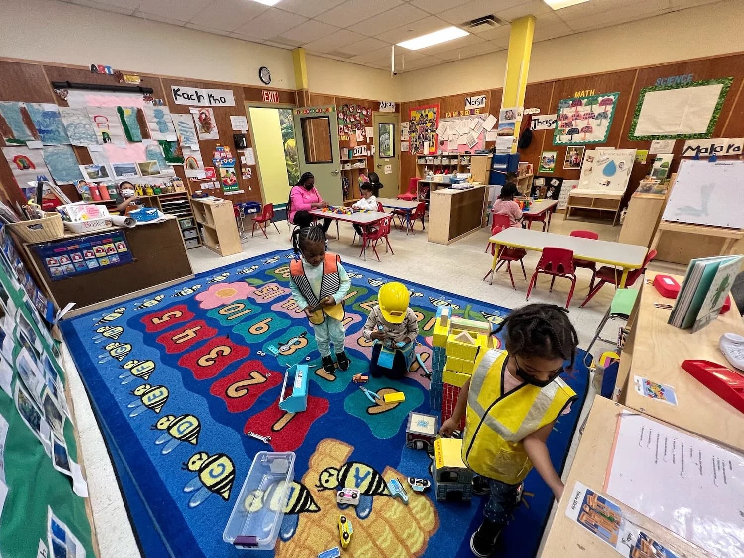 Children engaged in various learning activities across a well-equipped preschool classroom