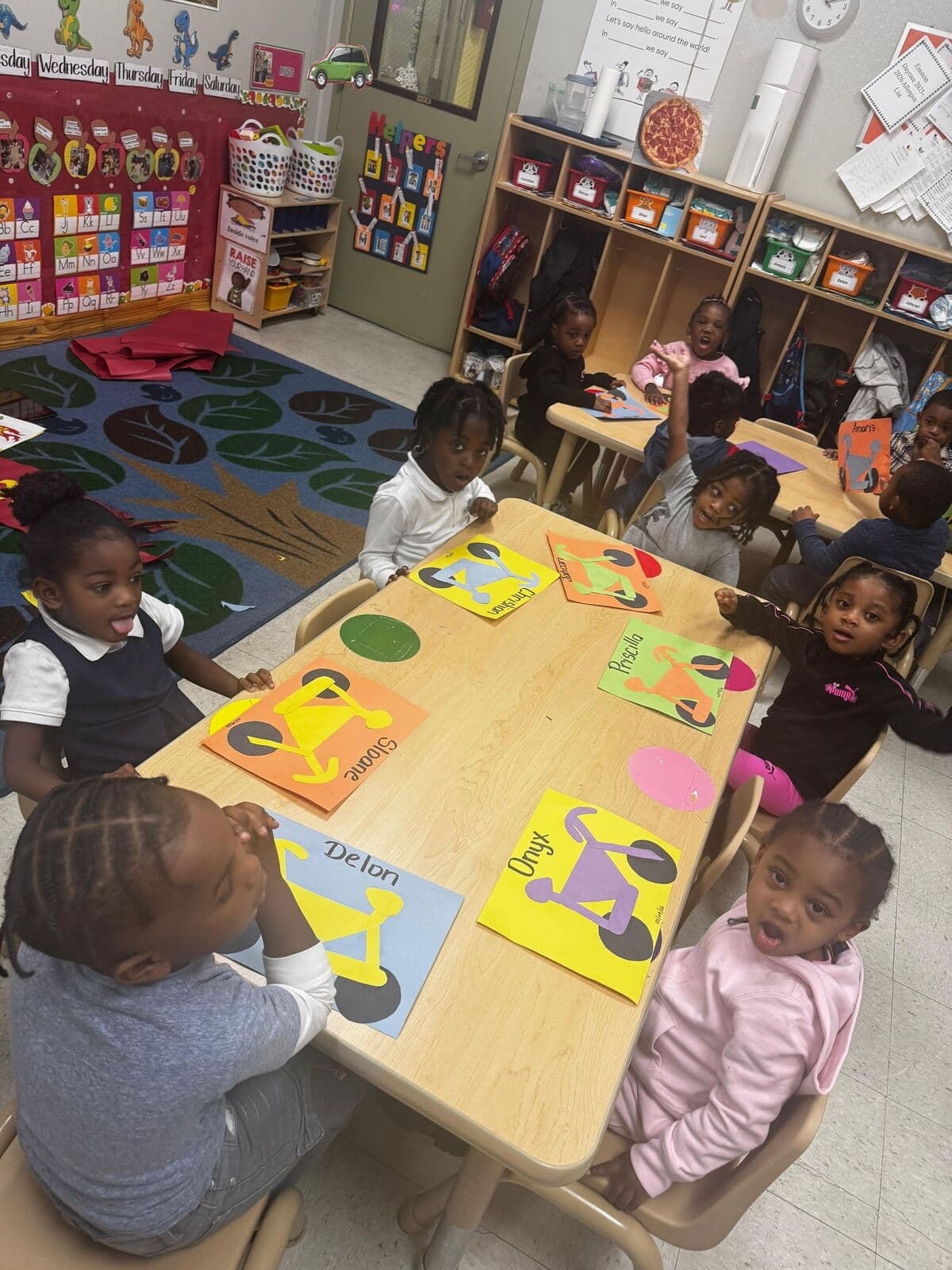 Children working on individualized art projects with names displayed at Einstein Daycare